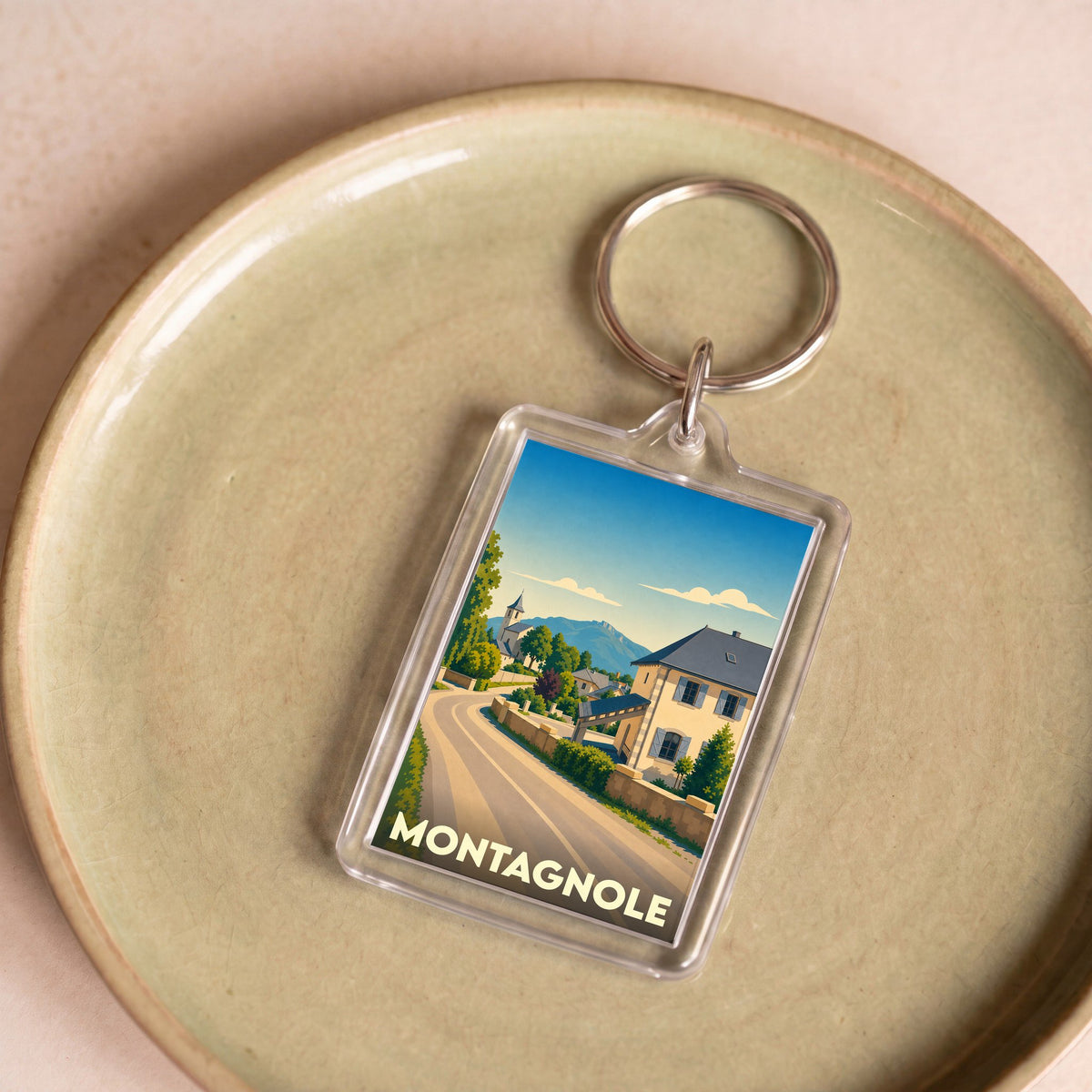 Porte-clés souvenir de la ville de Montagnole avec une illustration stylisée.