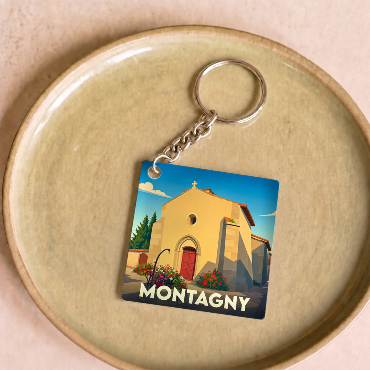 Porte-clés souvenir de la ville de Montagny avec une illustration stylisée de son église.