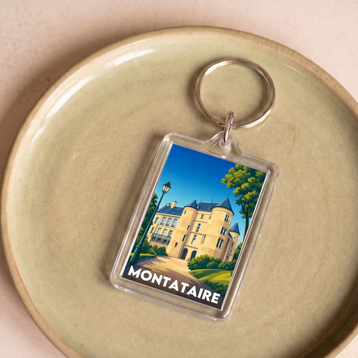 Porte-clés souvenir de la ville de Montataire avec une illustration stylisée.
