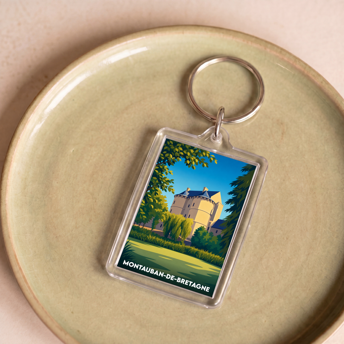 Porte-clés souvenir de la ville de Montauban-de-Bretagne avec une illustration stylisée d'un château.