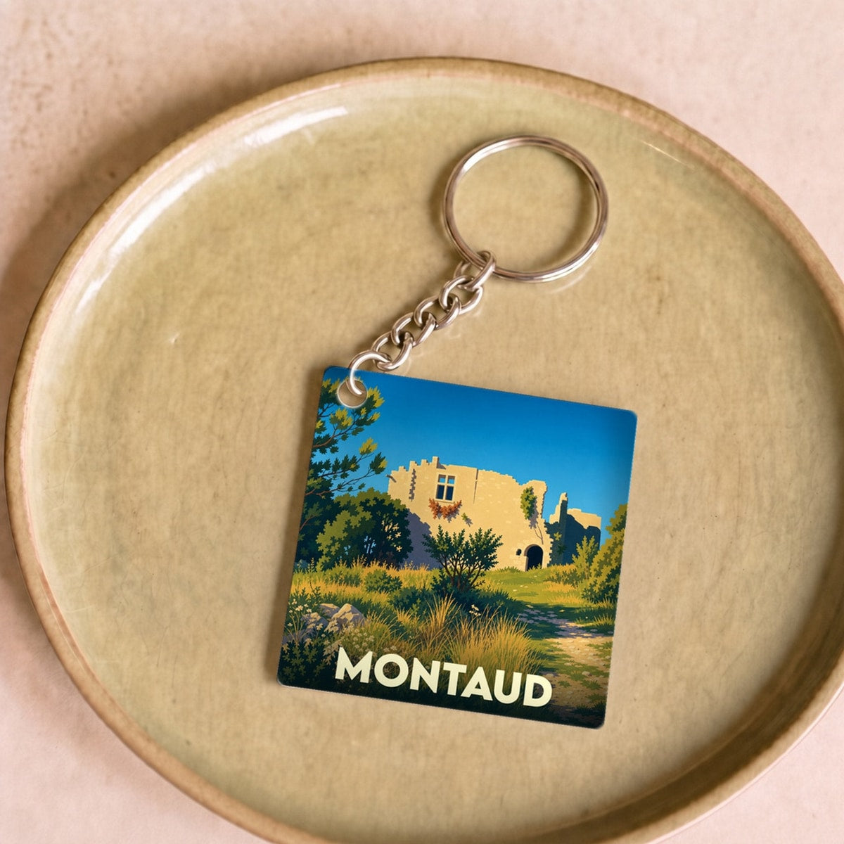 Porte-clés souvenir de la ville de Montaud avec une illustration stylisée.