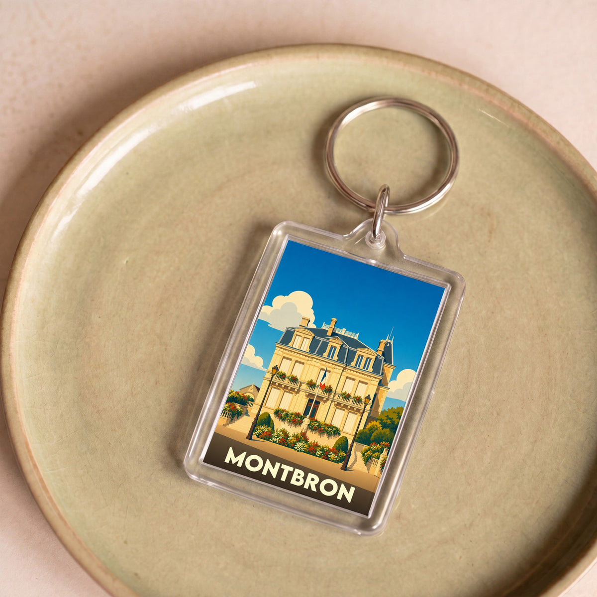 Porte-clés souvenir de la ville de Montbron avec une illustration stylisée de son hôtel de ville.