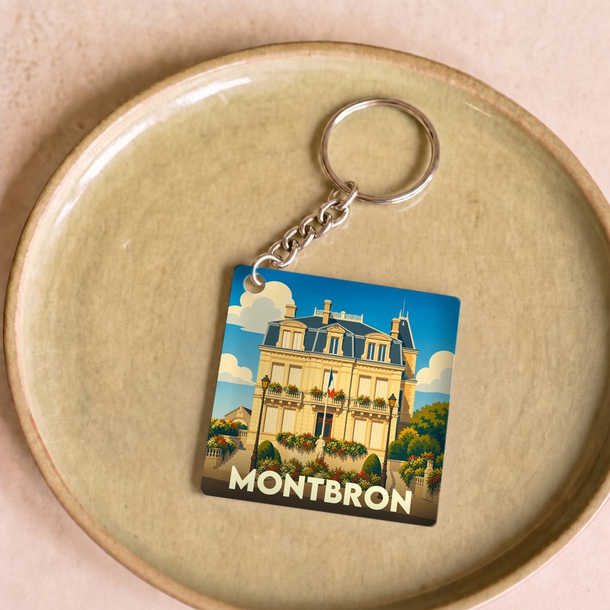Porte-clés souvenir de la ville de Montbron avec une illustration stylisée de son hôtel de ville.