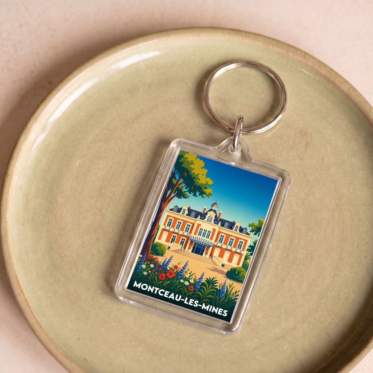 Porte-clés souvenir de la ville de Montceau-les-Mines avec une illustration stylisée.