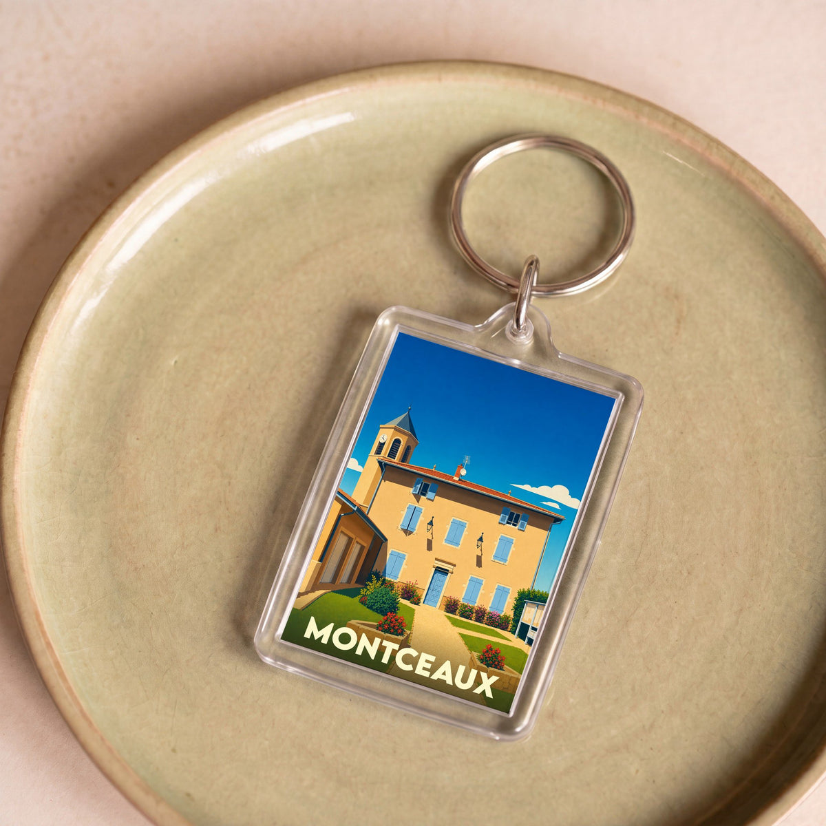 Porte-clés souvenir de la ville de Montceaux avec une illustration stylisée.