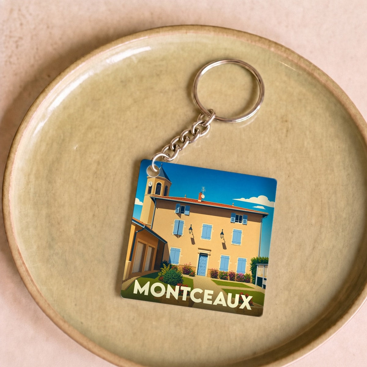 Porte-clés souvenir de la ville de Montceaux avec une illustration stylisée.