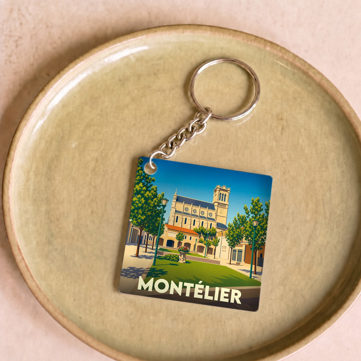 Porte-clés souvenir de la ville de Montélier avec une illustration stylisée.