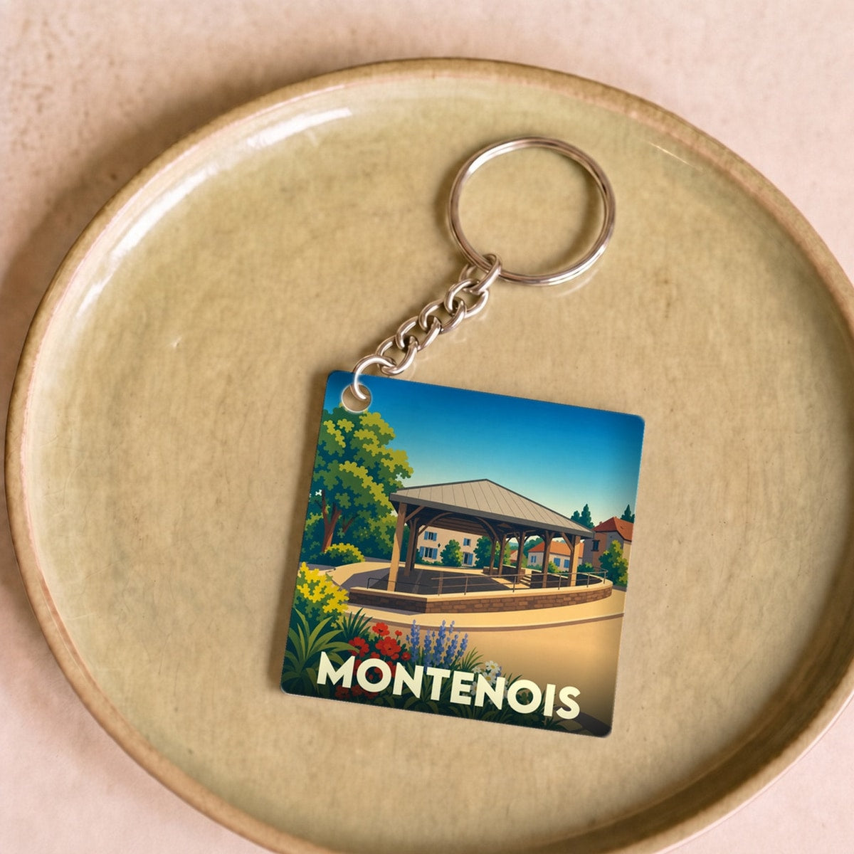Porte-clés souvenir de la ville de Montenois avec une illustration stylisée.