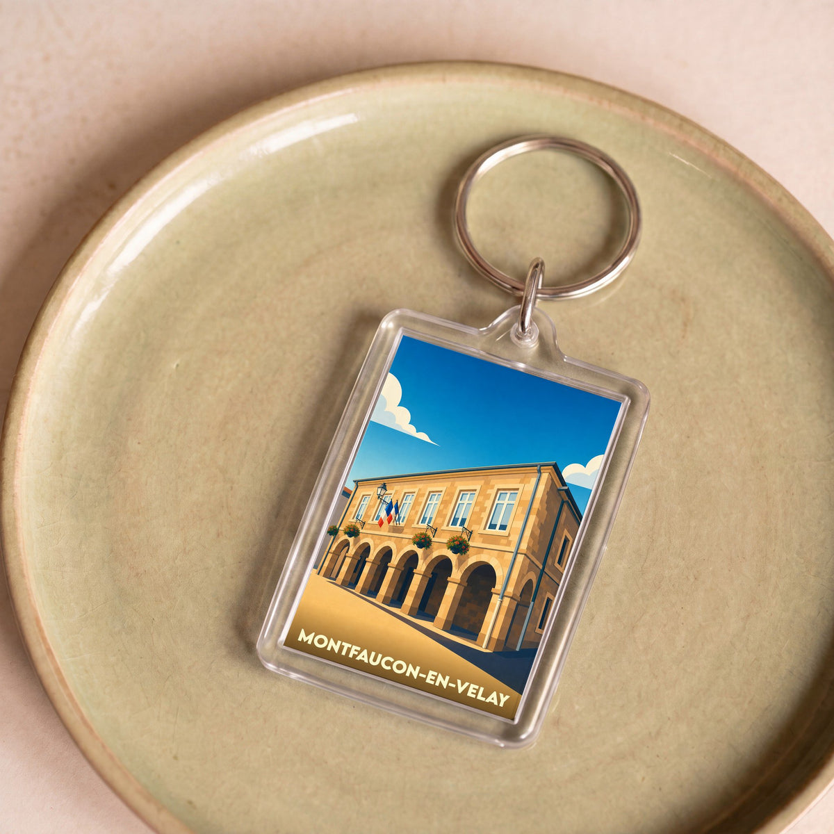 Porte-clés souvenir de la ville de Montfaucon-en-Velay avec une illustration stylisée de sa mairie.