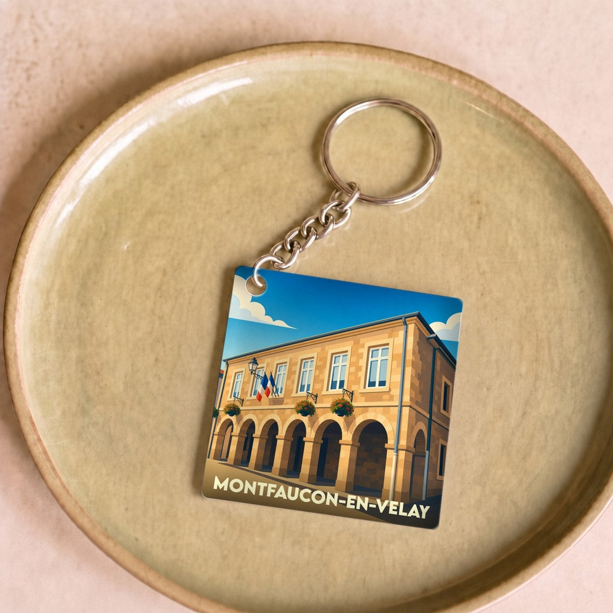 Porte-clés souvenir de la ville de Montfaucon-en-Velay avec une illustration stylisée de sa mairie.