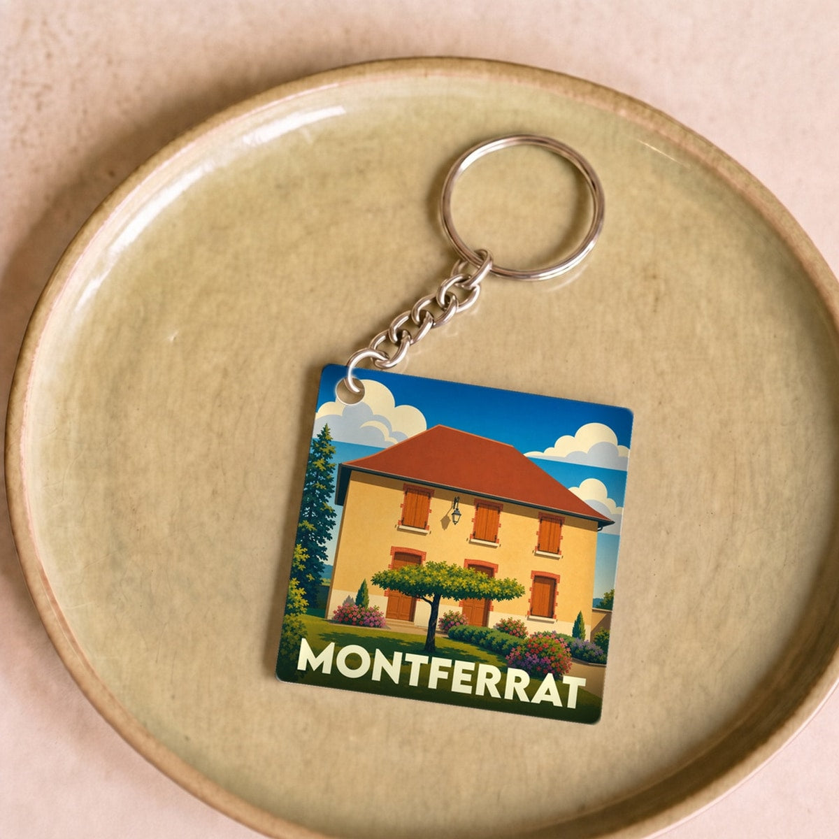 Porte-clés souvenir de la ville de Montferrat avec une illustration stylisée d'une maison provençale.