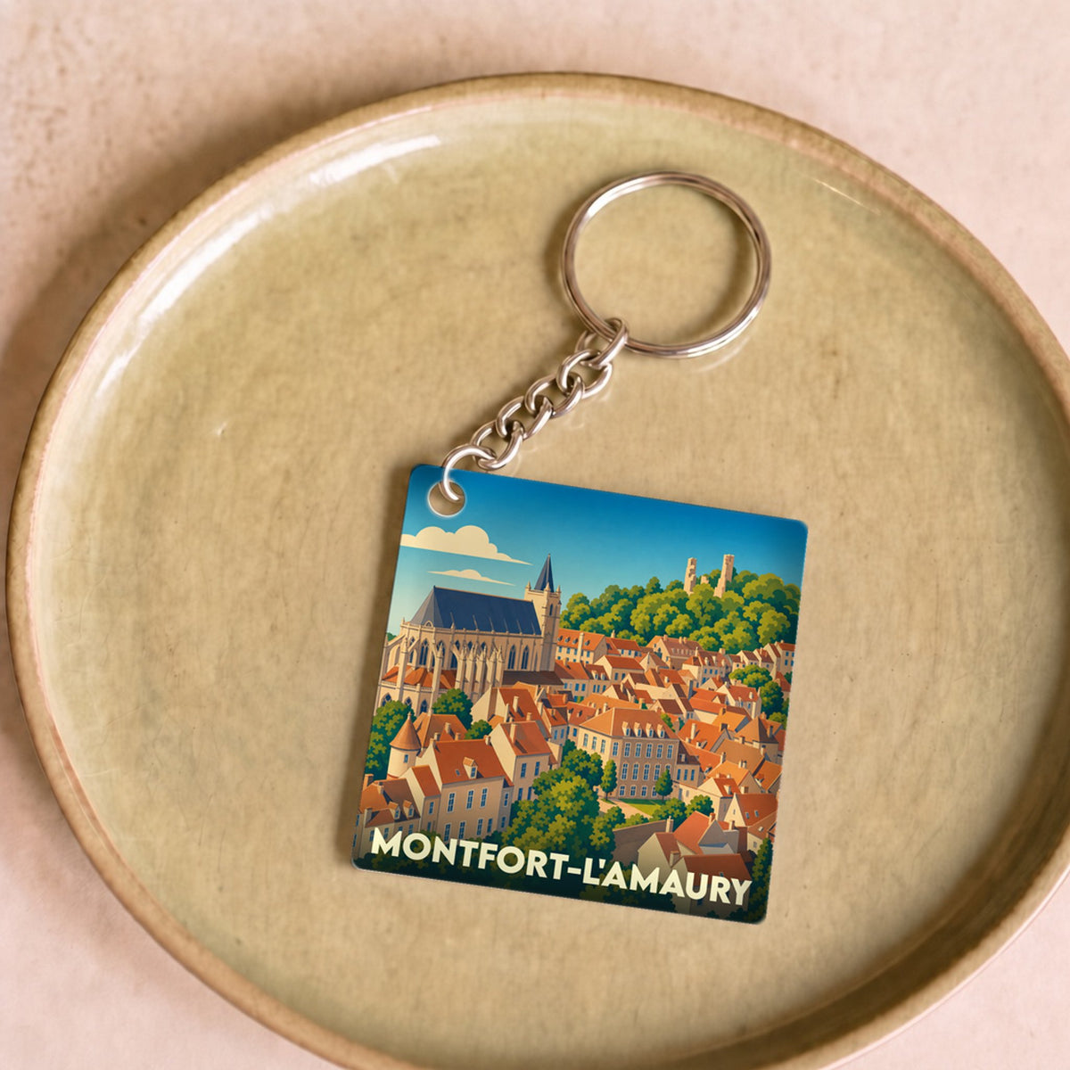 Porte-clés souvenir de la ville de Montfort-l'Amaury avec une illustration stylisée.