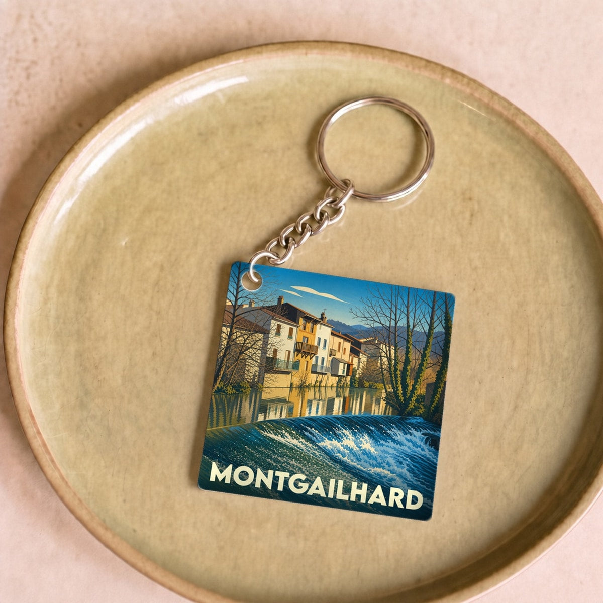 Porte-clés souvenir de la ville de Montgailhard avec une illustration stylisée.