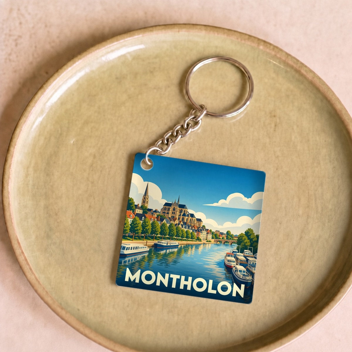 Porte-clés souvenir de la ville de Montholon avec une illustration stylisée des bords de l’Yonne.