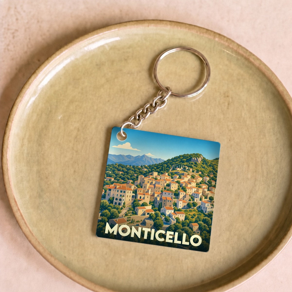 Porte-clés souvenir de la ville de Monticello avec une illustration stylisée d'un village corse.