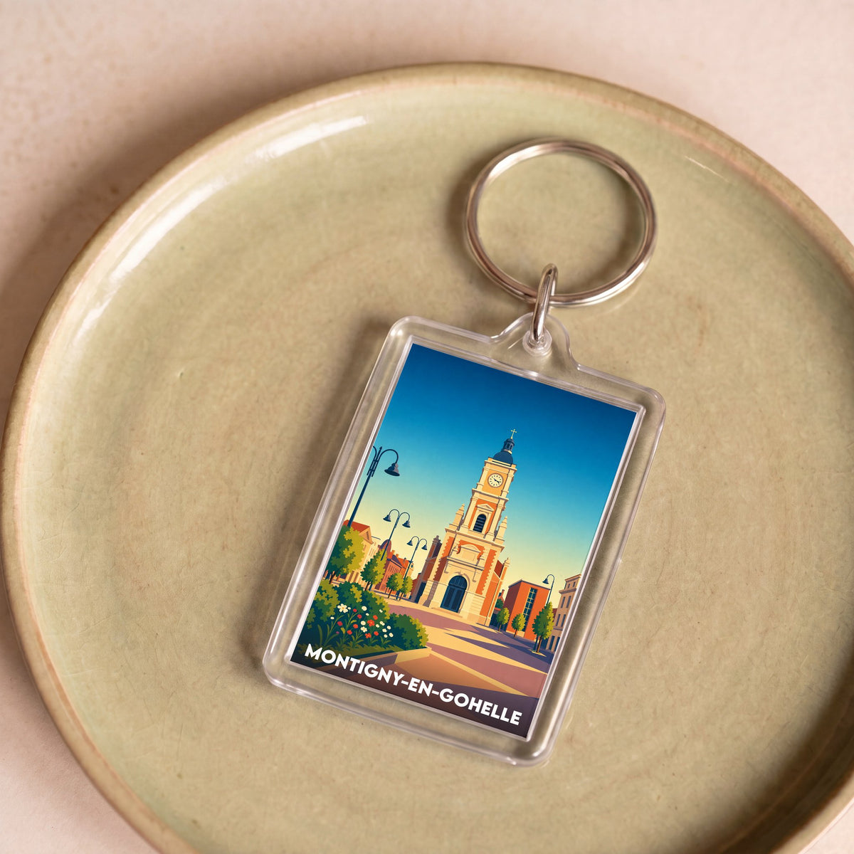 Porte-clés souvenir de la ville de Montigny-en-Gohelle avec une illustration stylisée.
