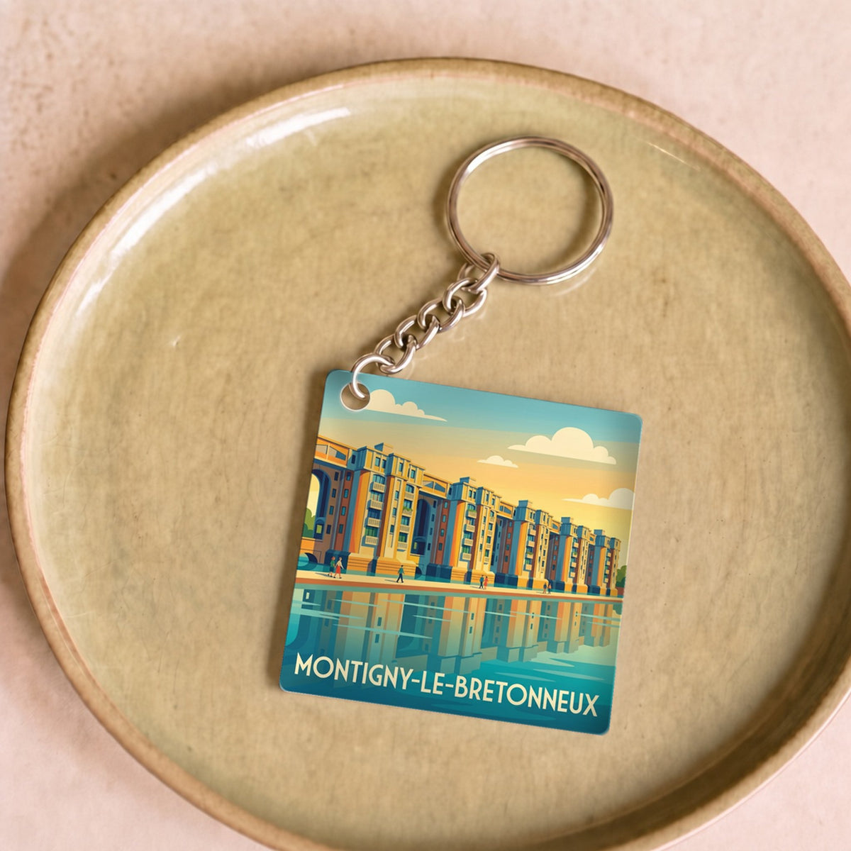 Porte-clés souvenir de la ville de Montigny-le-Bretonneux avec une illustration stylisée.