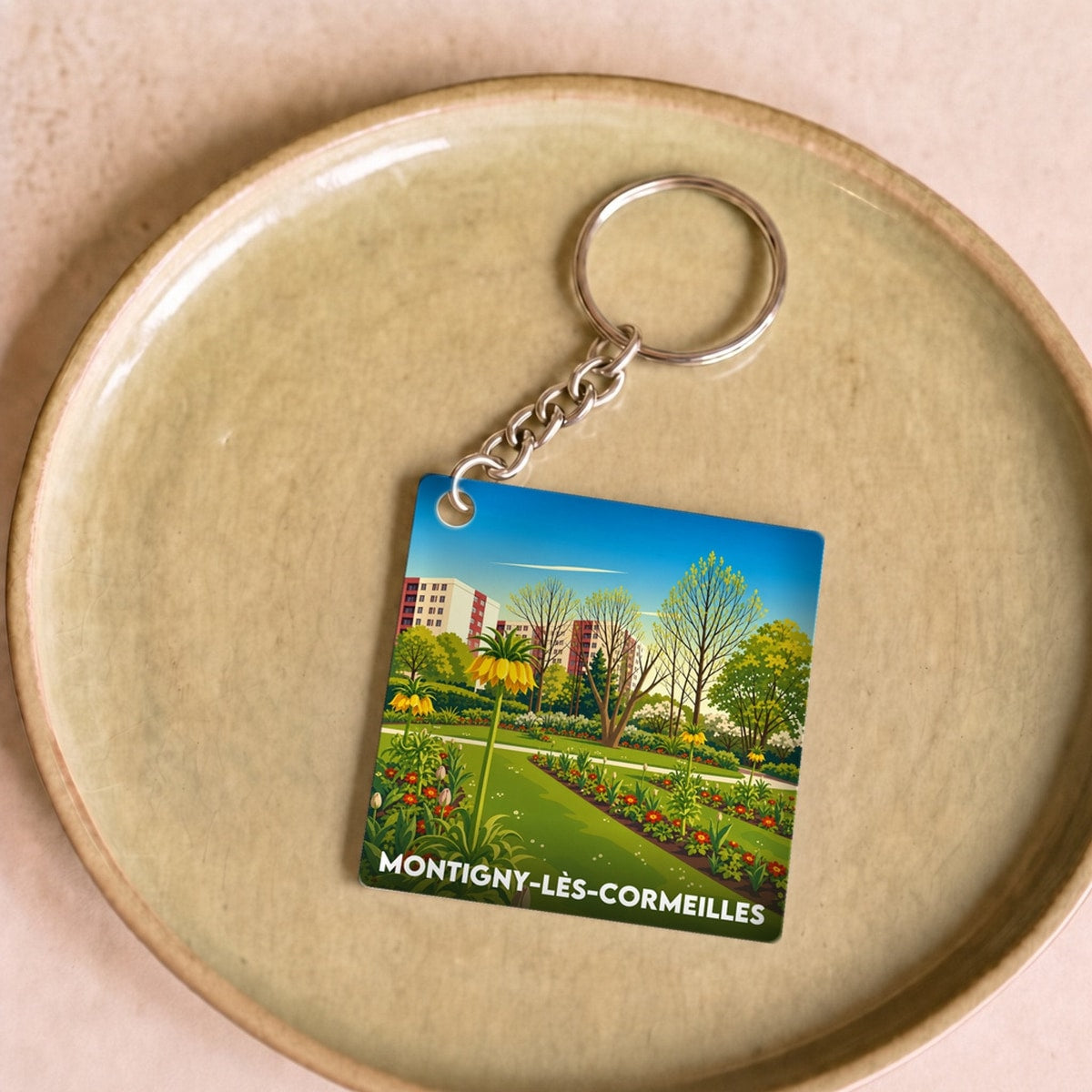Porte-clés souvenir de la ville de Montigny-lès-Cormeilles avec une illustration stylisée.