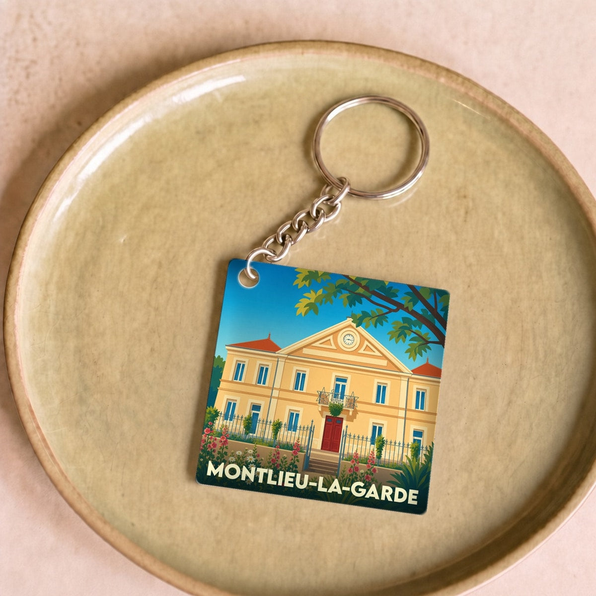 Porte-clés souvenir de la ville de Montlieu-la-Garde avec une illustration stylisée.