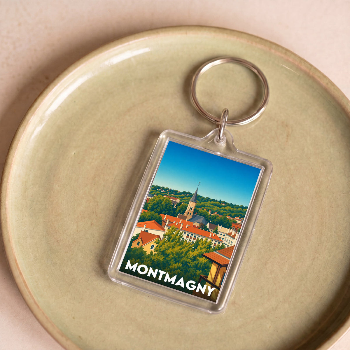 Porte-clés souvenir de la ville de Montmagny avec une illustration stylisée.