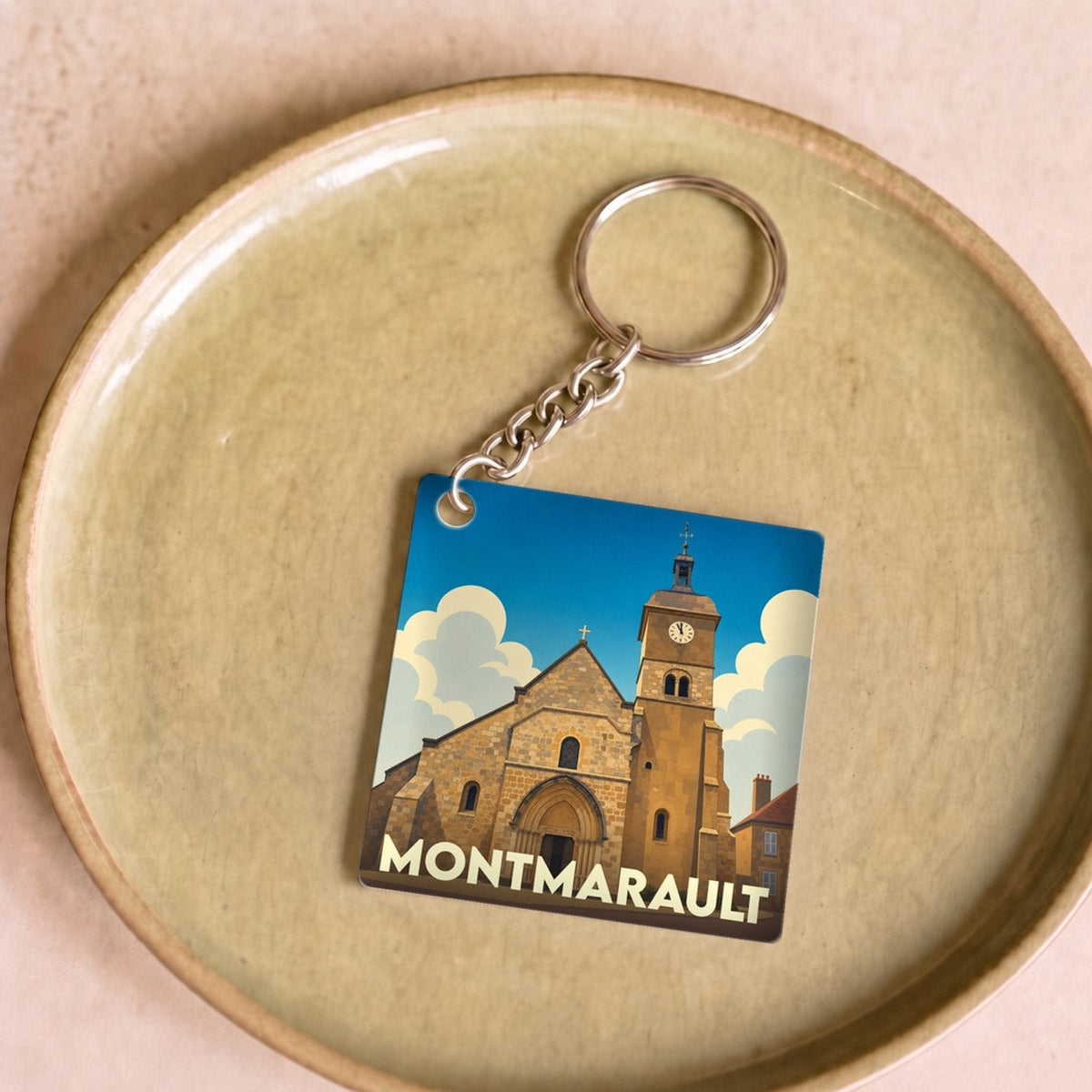 Porte-clés souvenir de la ville de Montmarault avec une illustration stylisée de son église.