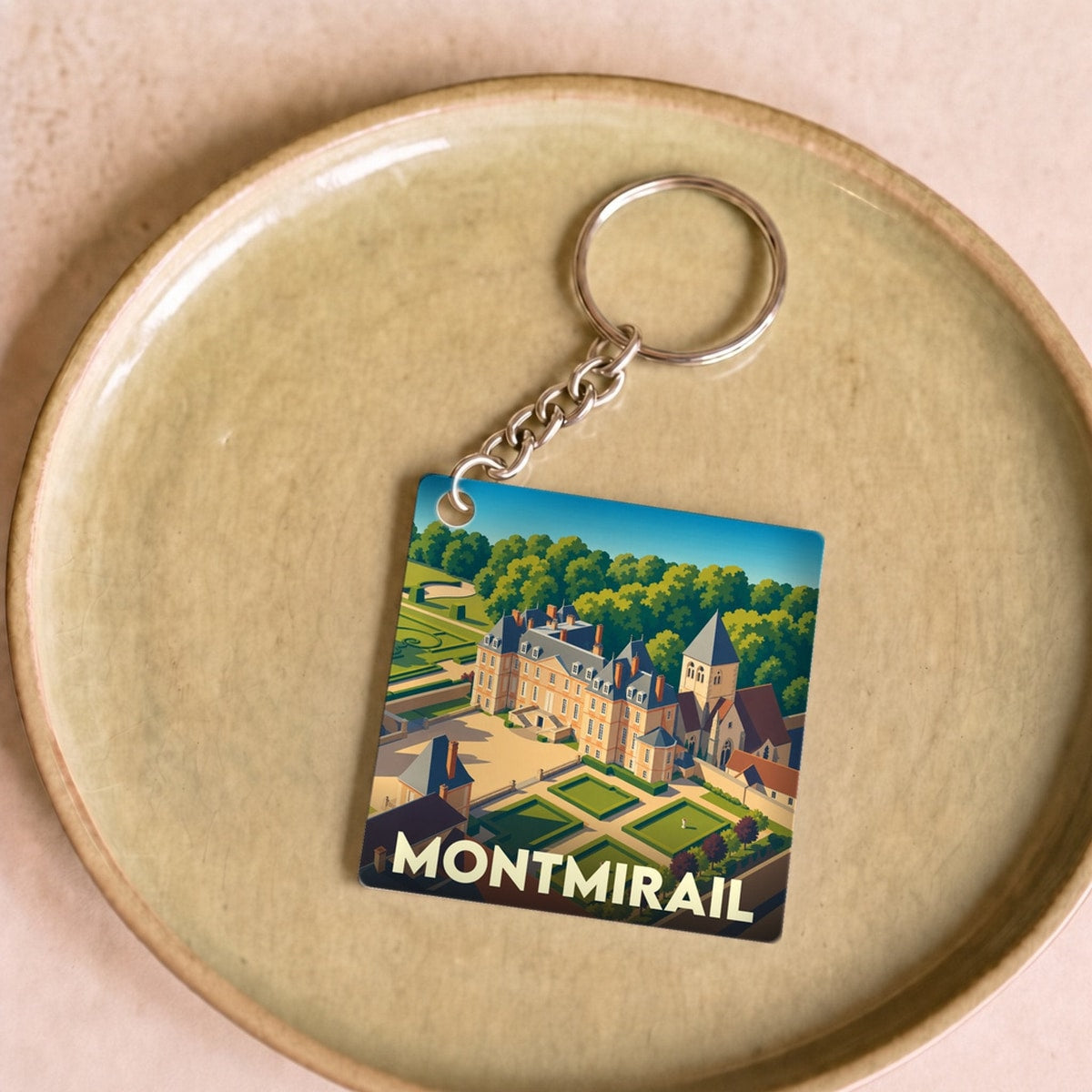 Porte-clés souvenir de la ville de Montmirail avec une illustration stylisée de son château et de ses jardins.