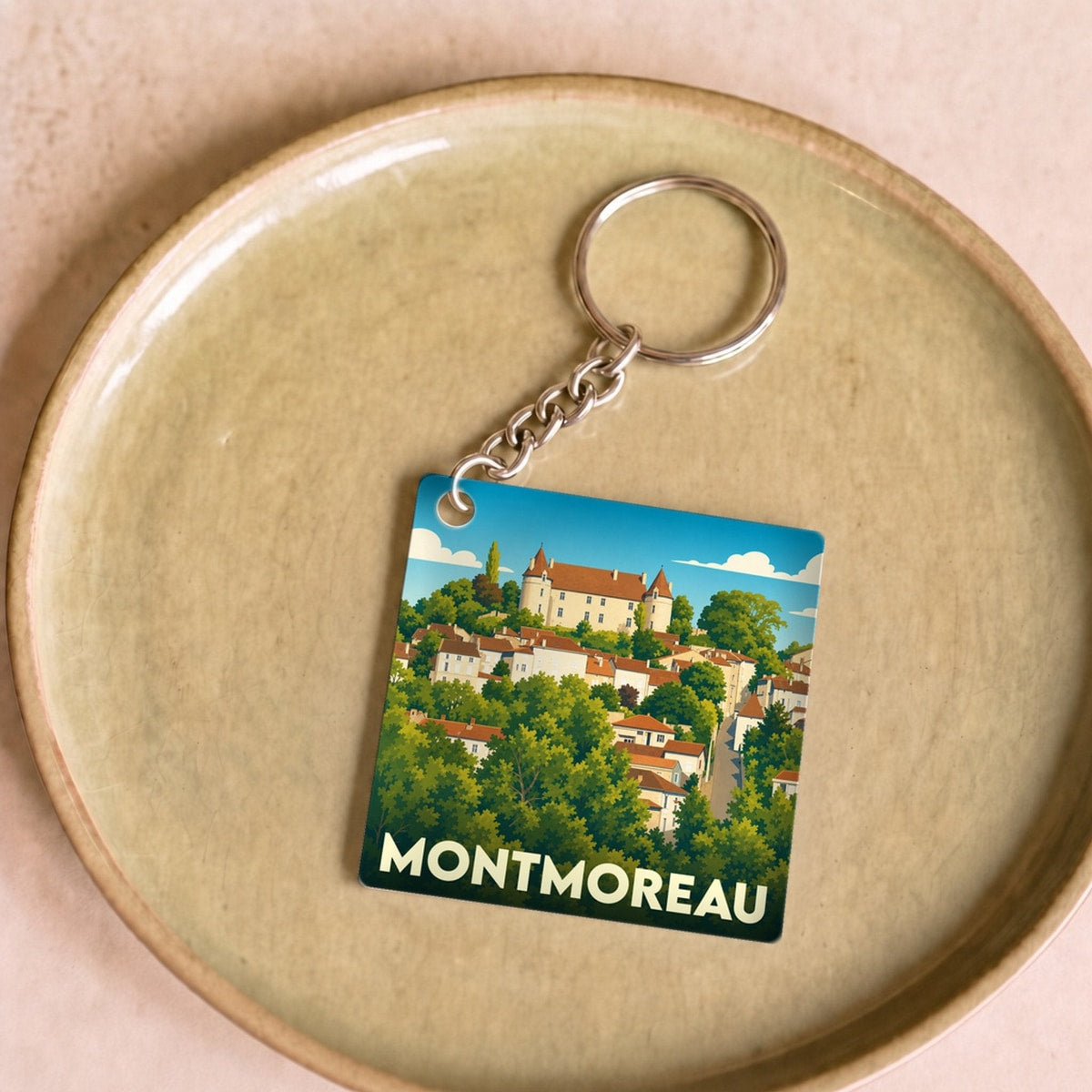 Porte-clés souvenir de la ville de Montmoreau avec une illustration stylisée.