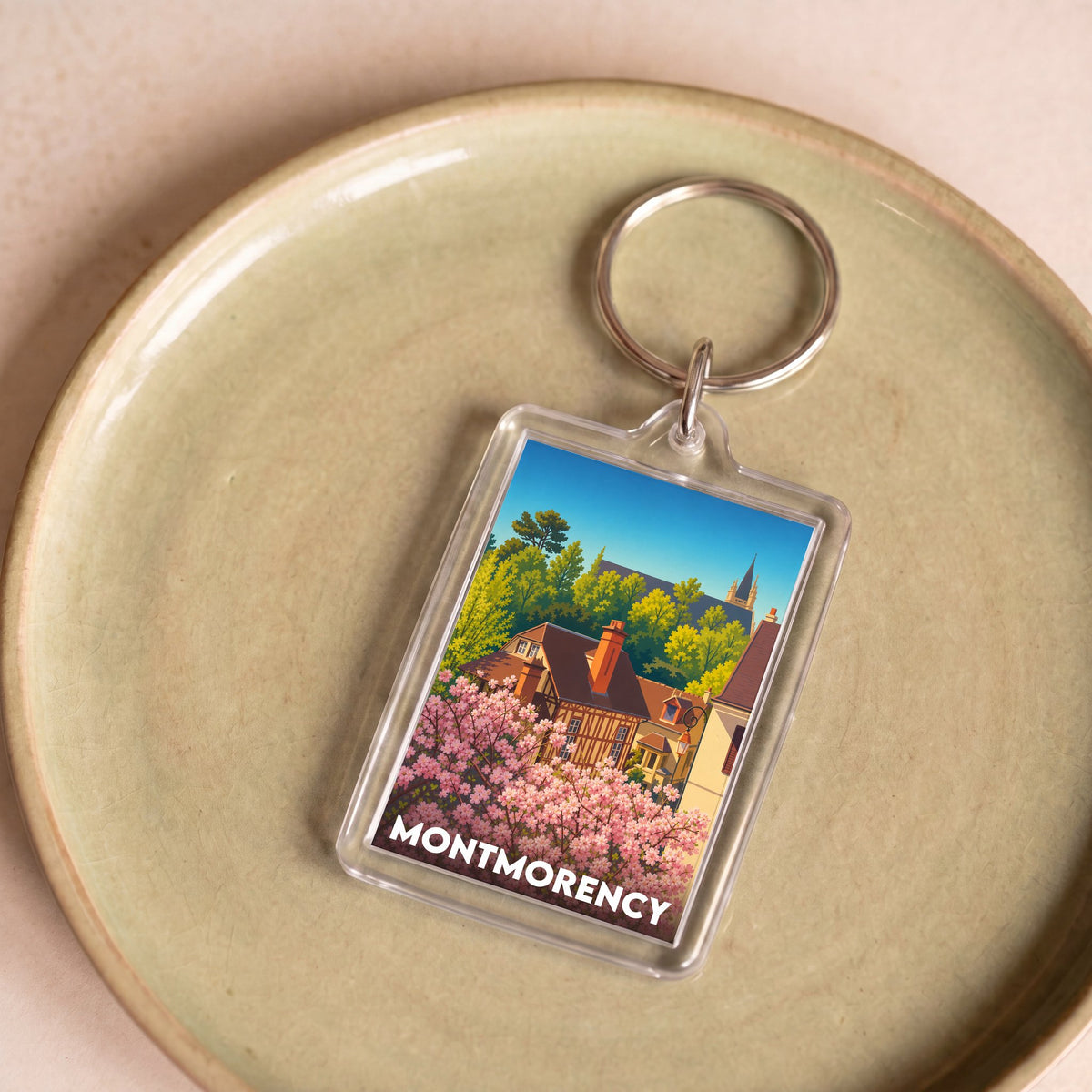 Porte-clés souvenir de la ville de Montmorency avec une illustration stylisée.