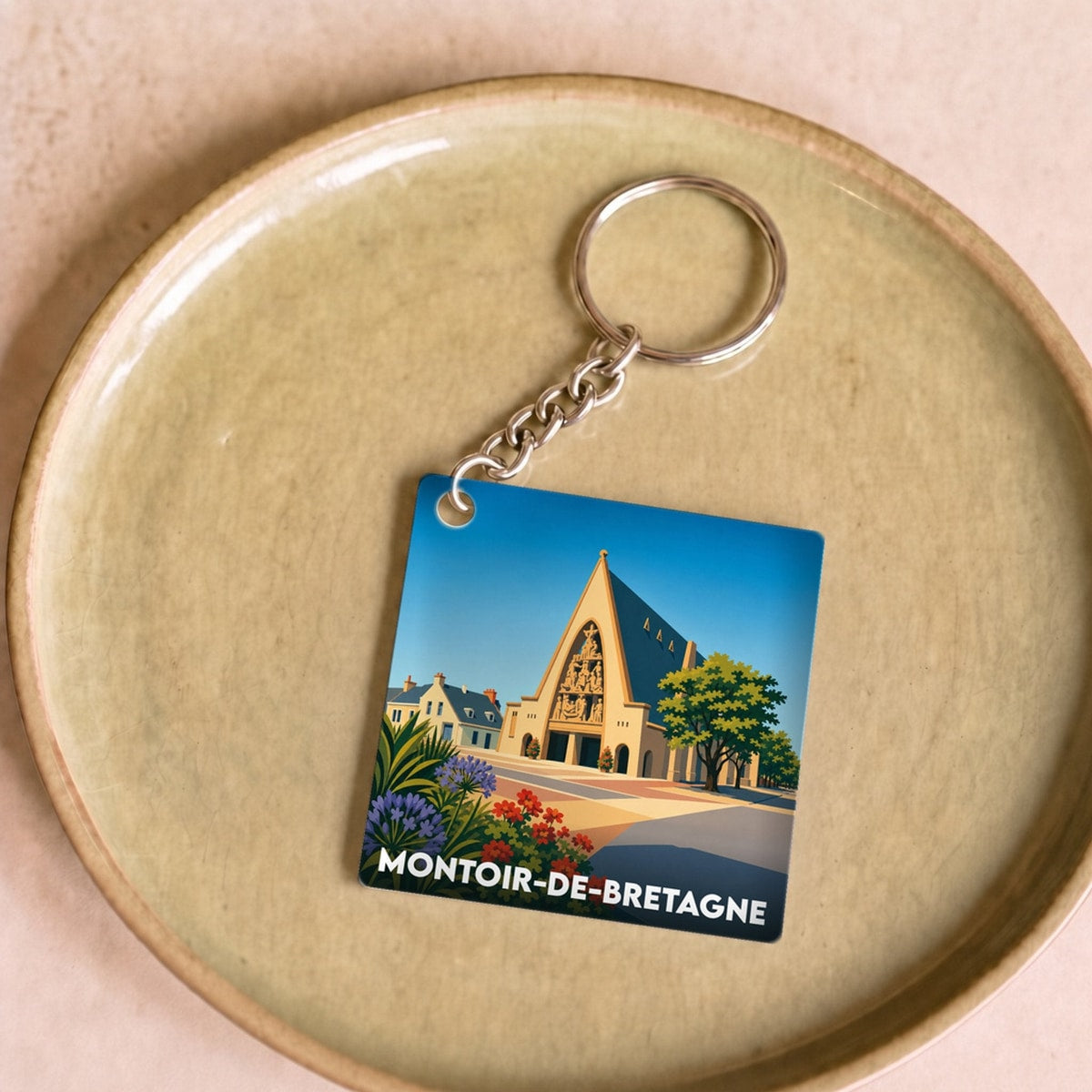 Porte-clés souvenir de la ville de Montoir-de-Bretagne avec une illustration stylisée.