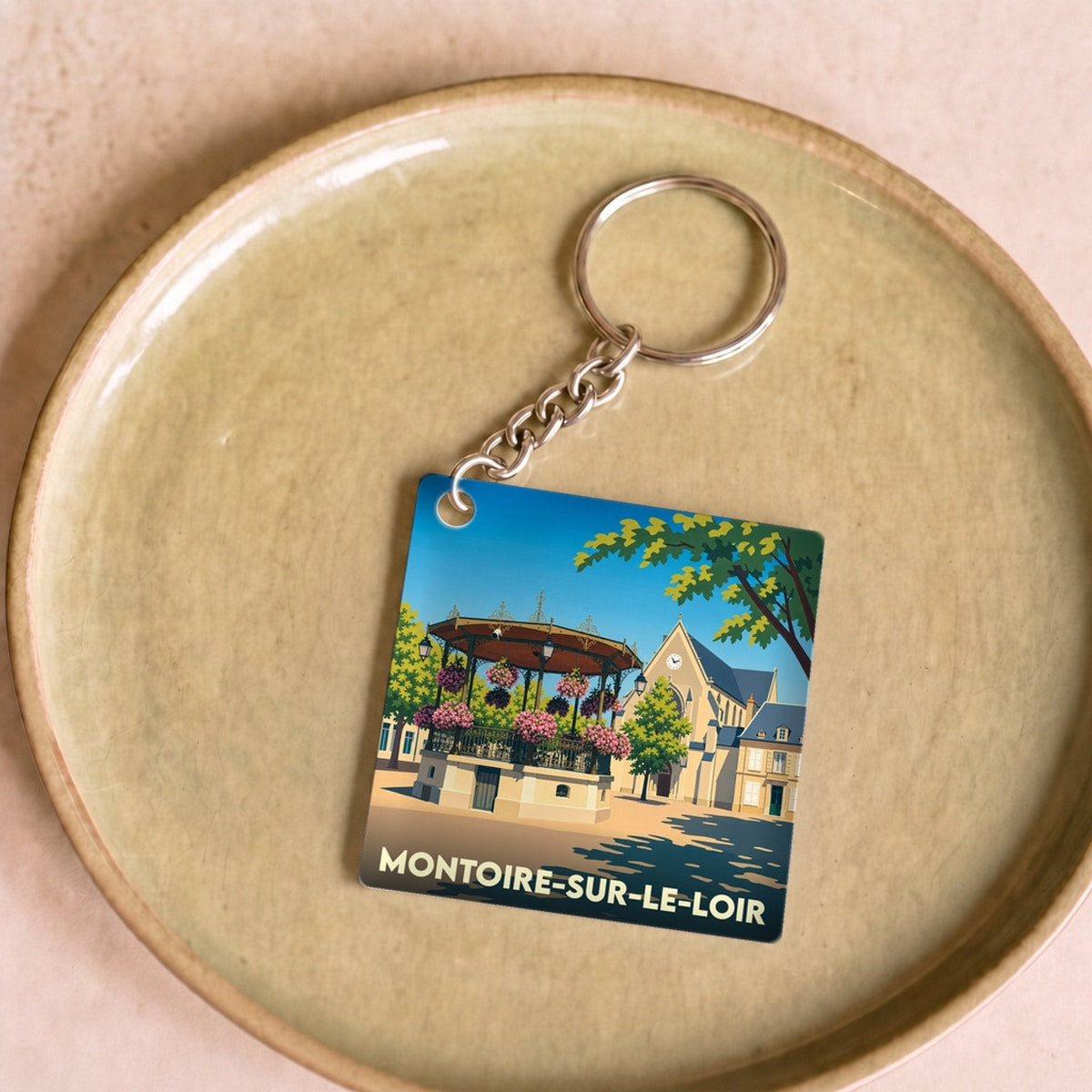 Porte-clés souvenir de la ville de Montoire-sur-le-Loir avec une illustration stylisée.