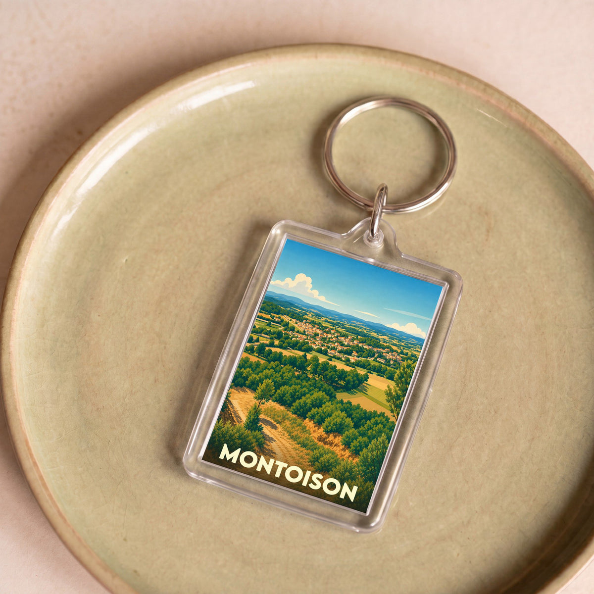 Porte-clés souvenir de la ville de Montoison avec une illustration paysagère stylisée.
