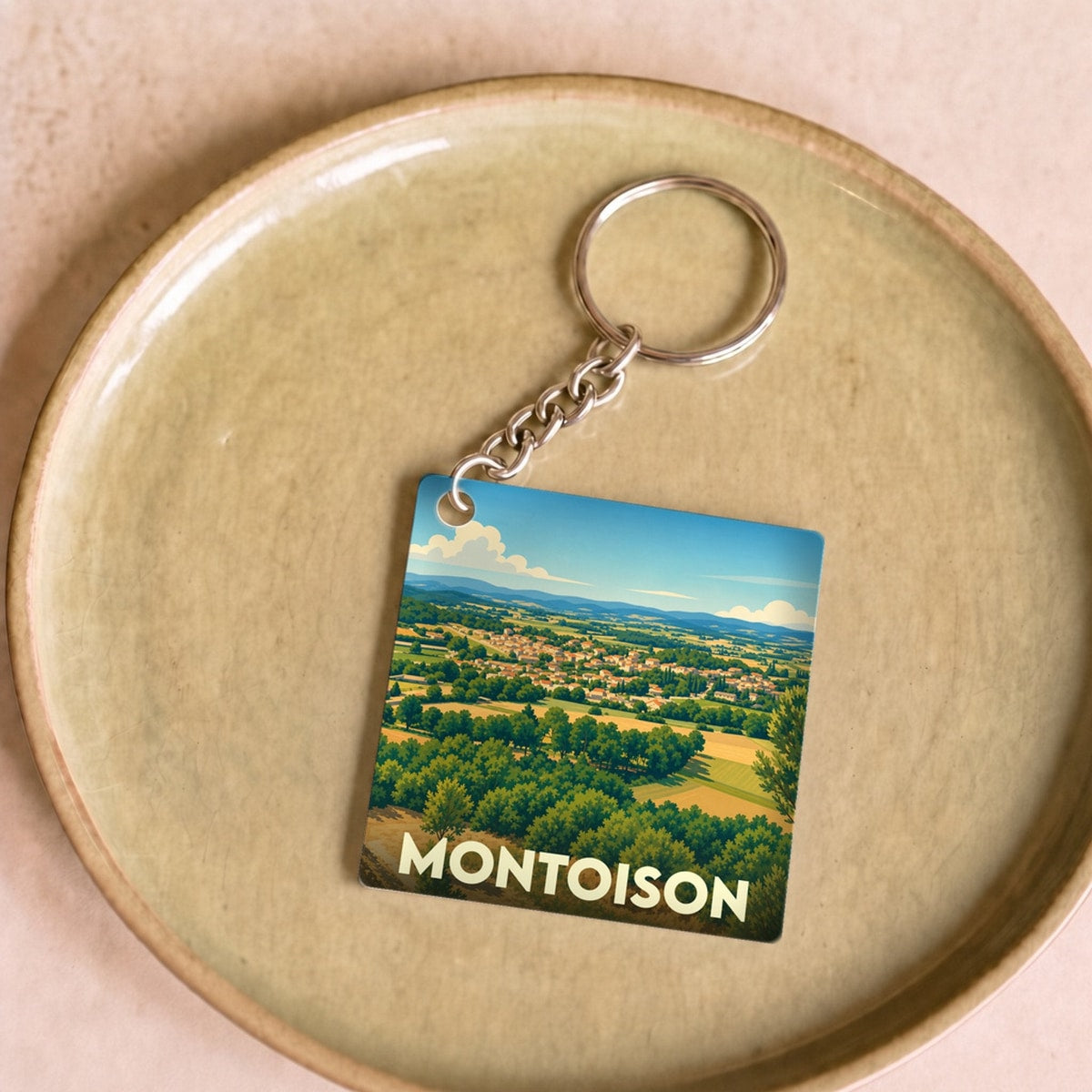 Porte-clés souvenir de la ville de Montoison avec une illustration paysagère stylisée.