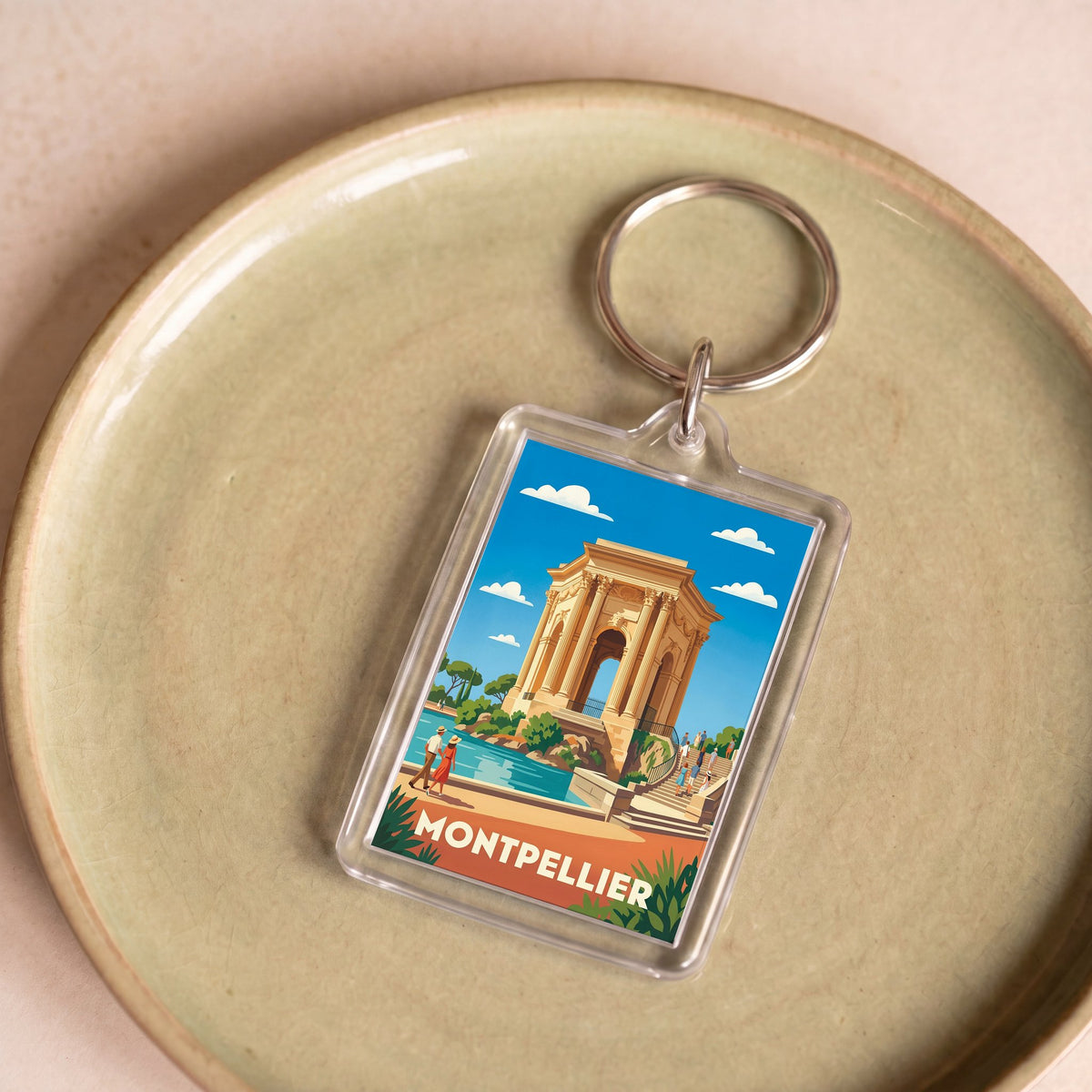 Porte-clés souvenir de la ville de Montpellier avec une illustration stylisée.