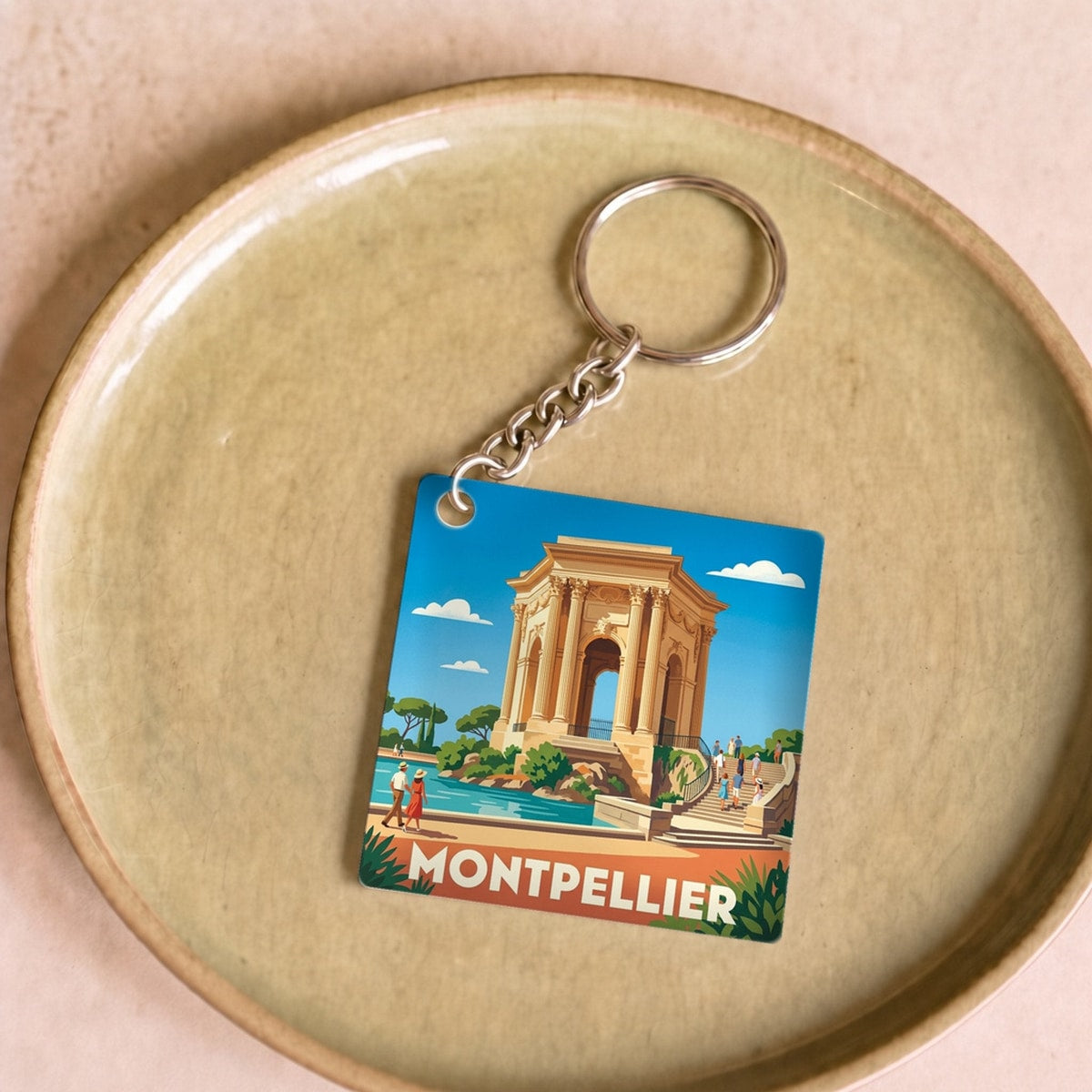 Porte-clés souvenir de la ville de Montpellier avec une illustration stylisée.