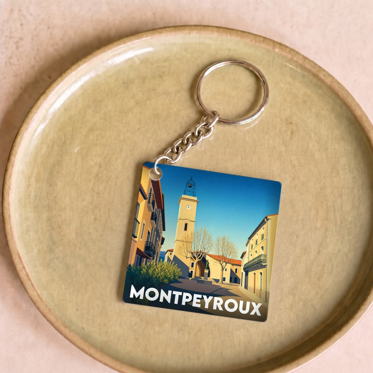 Porte-clés souvenir de la ville de Montpeyroux avec une illustration stylisée.