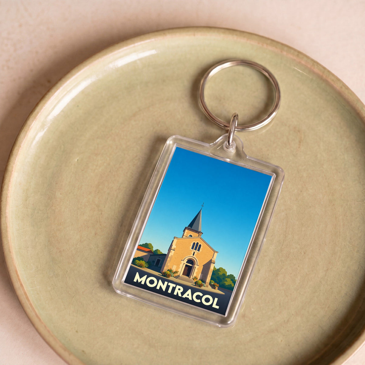 Porte-clés souvenir de la ville de Montracol avec une illustration stylisée de son église.