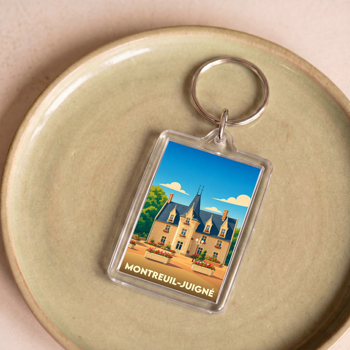 Porte-clés souvenir de la ville de Montreuil-Juigné avec une illustration stylisée de l'hôtel de ville.
