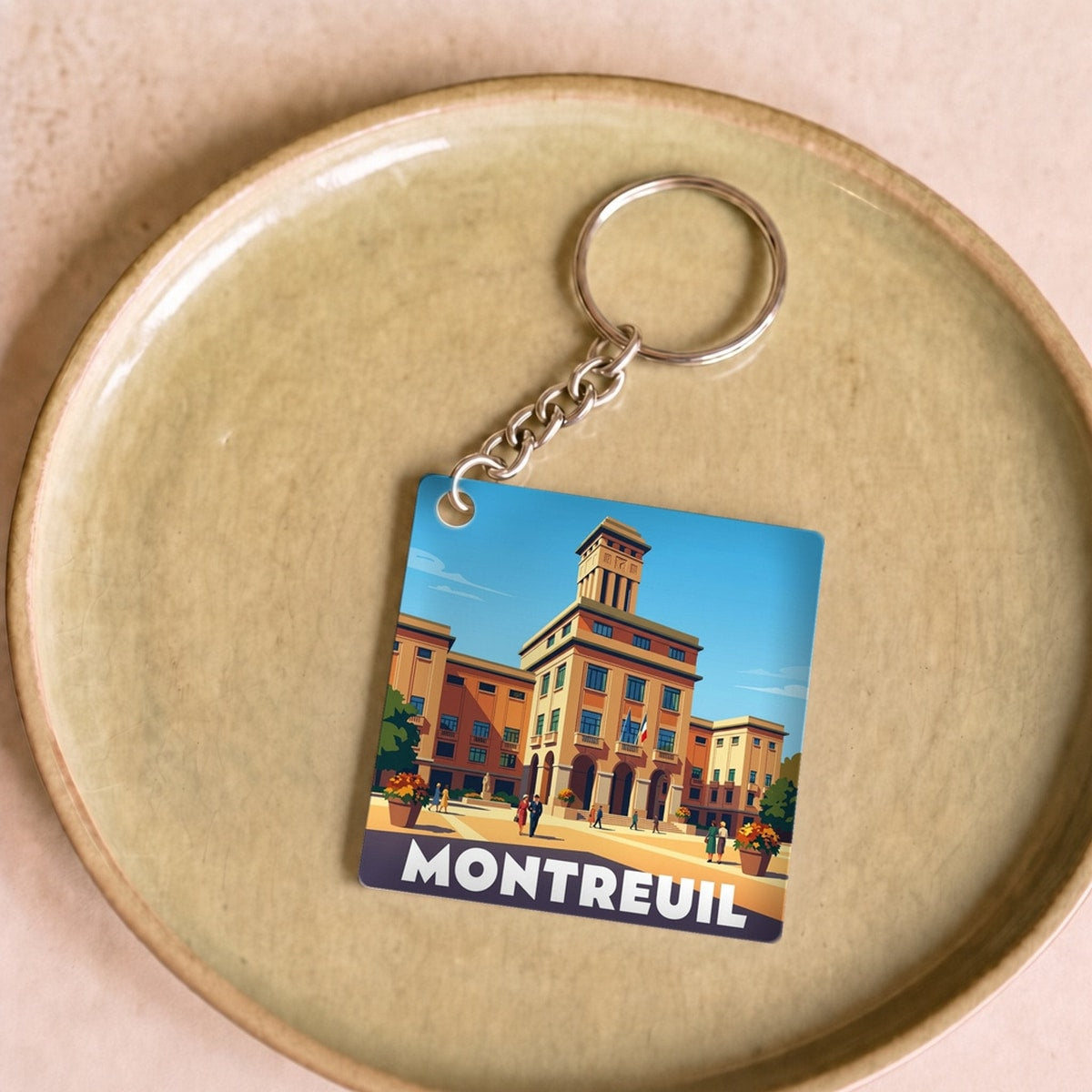 Porte-clés souvenir de la ville de Montreuil avec une illustration stylisée.