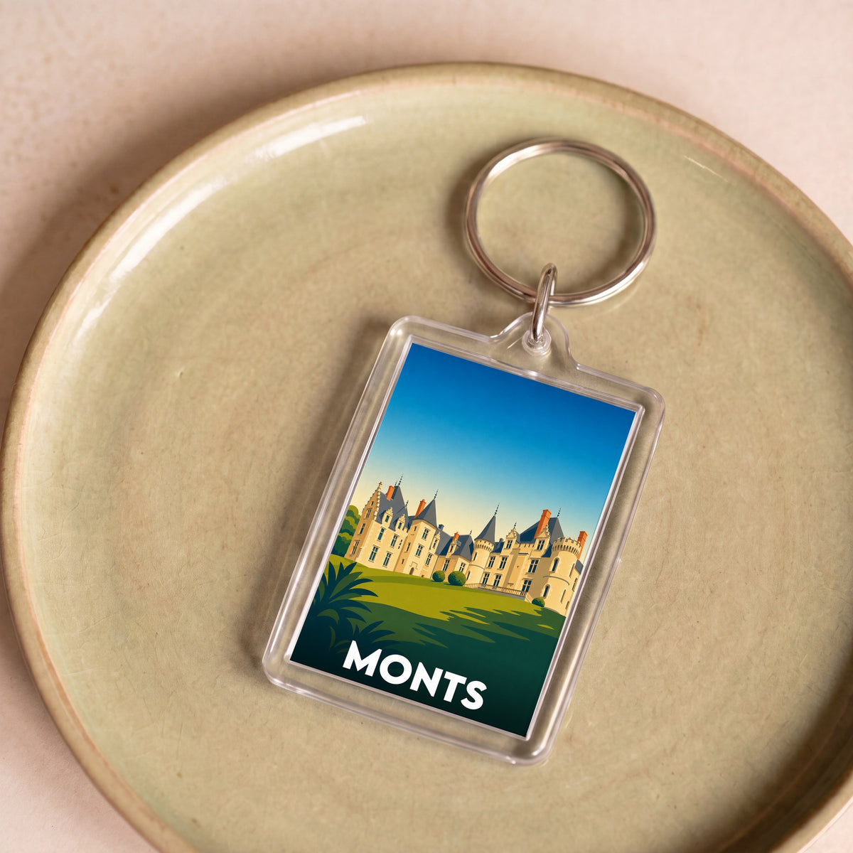 Porte-clés souvenir de la ville de Monts avec une illustration stylisée d'un château.