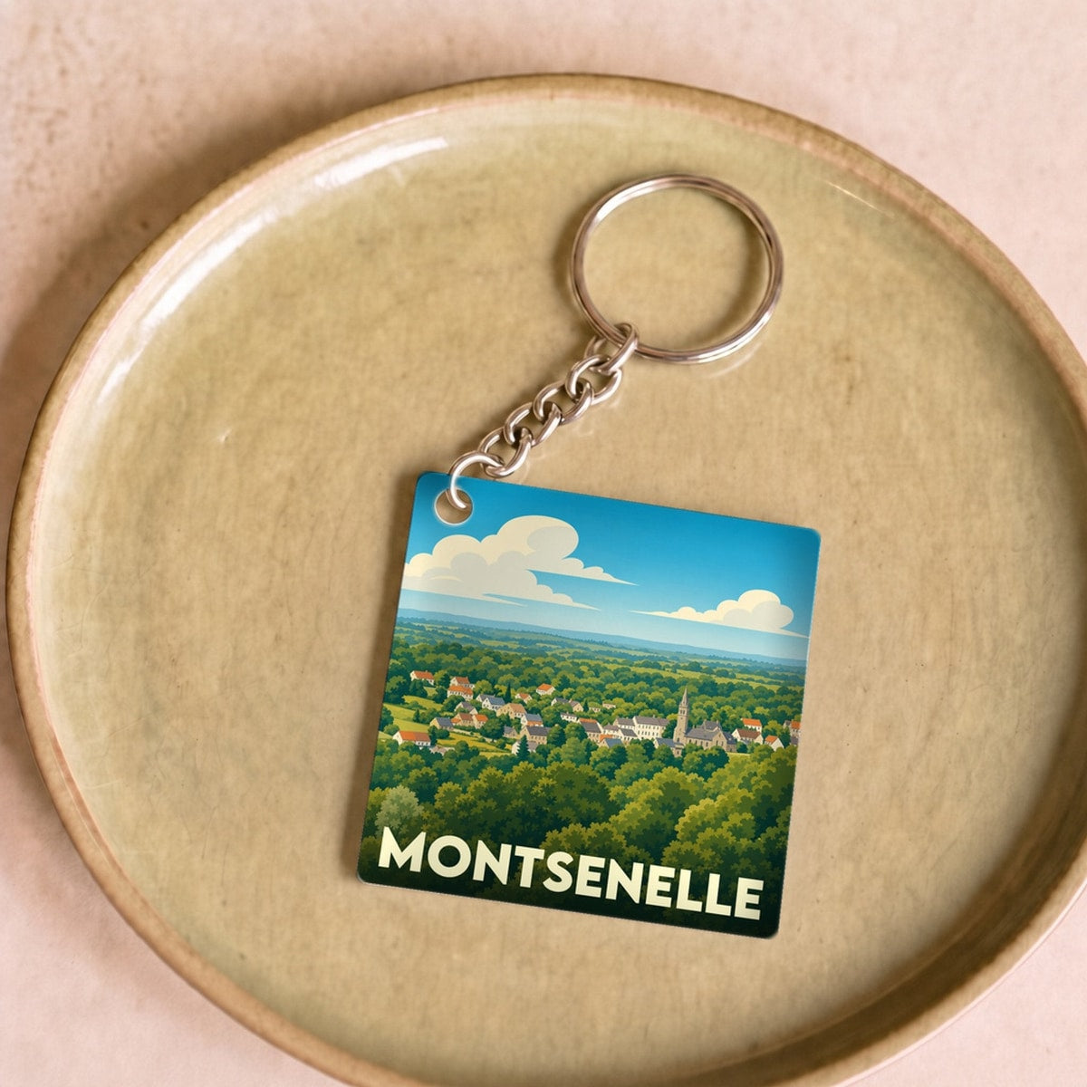 Porte-clés souvenir de la ville de Montsenelle avec une illustration paysagère stylisée.