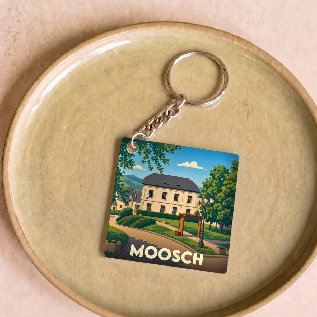 Porte-clés souvenir de la ville de Moosch avec une illustration stylisée.