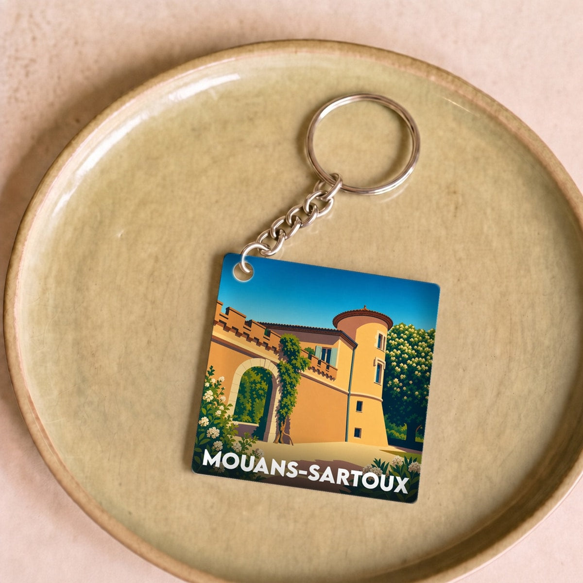 Porte-clés souvenir de la ville de Mouans-Sartoux avec une illustration stylisée de son château.