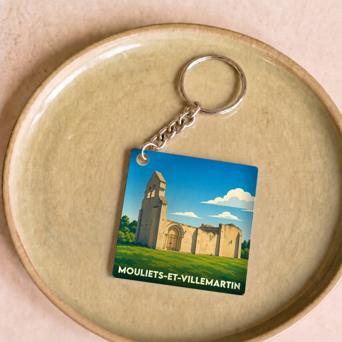 Porte-clés souvenir de la ville de Mouliets-et-Villemartin avec une illustration stylisée de ses ruines historiques.