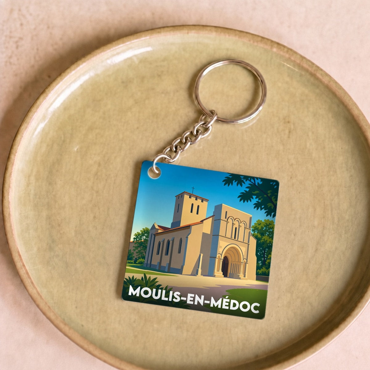 Porte-clés souvenir de la ville de Moulis-en-Médoc avec une illustration stylisée.