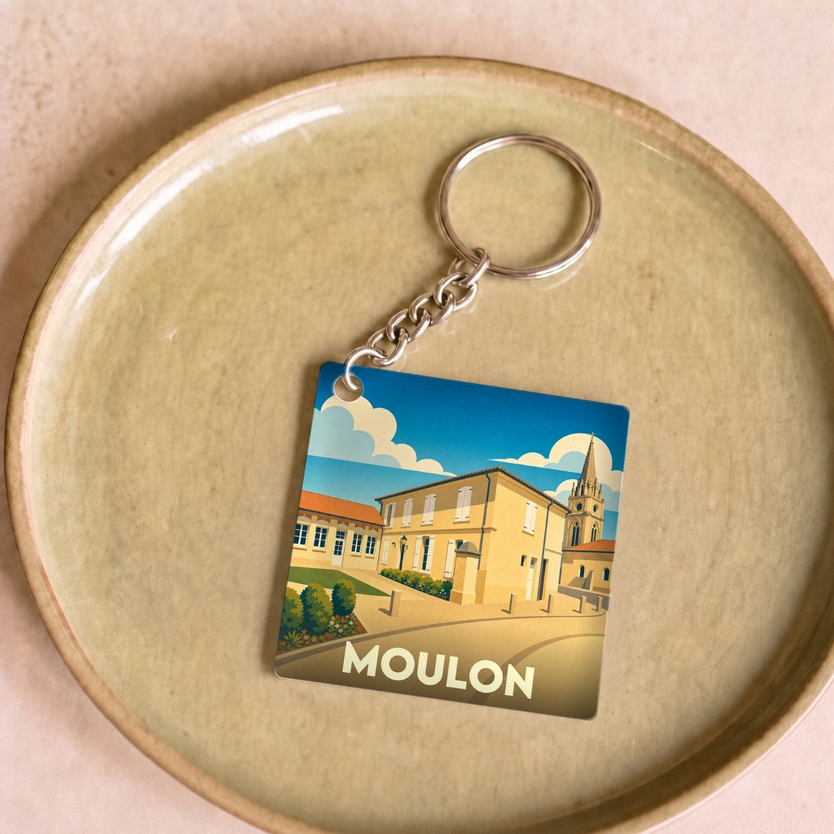 Porte-clés souvenir de la ville de Moulon avec une illustration stylisée.