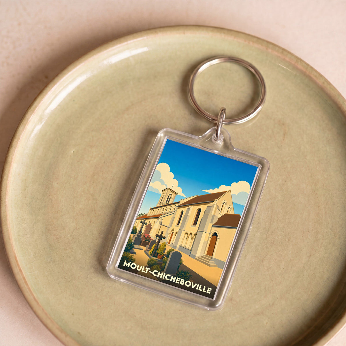 Porte-clés souvenir de la ville de Moult-Chicheboville avec une illustration stylisée de son église.