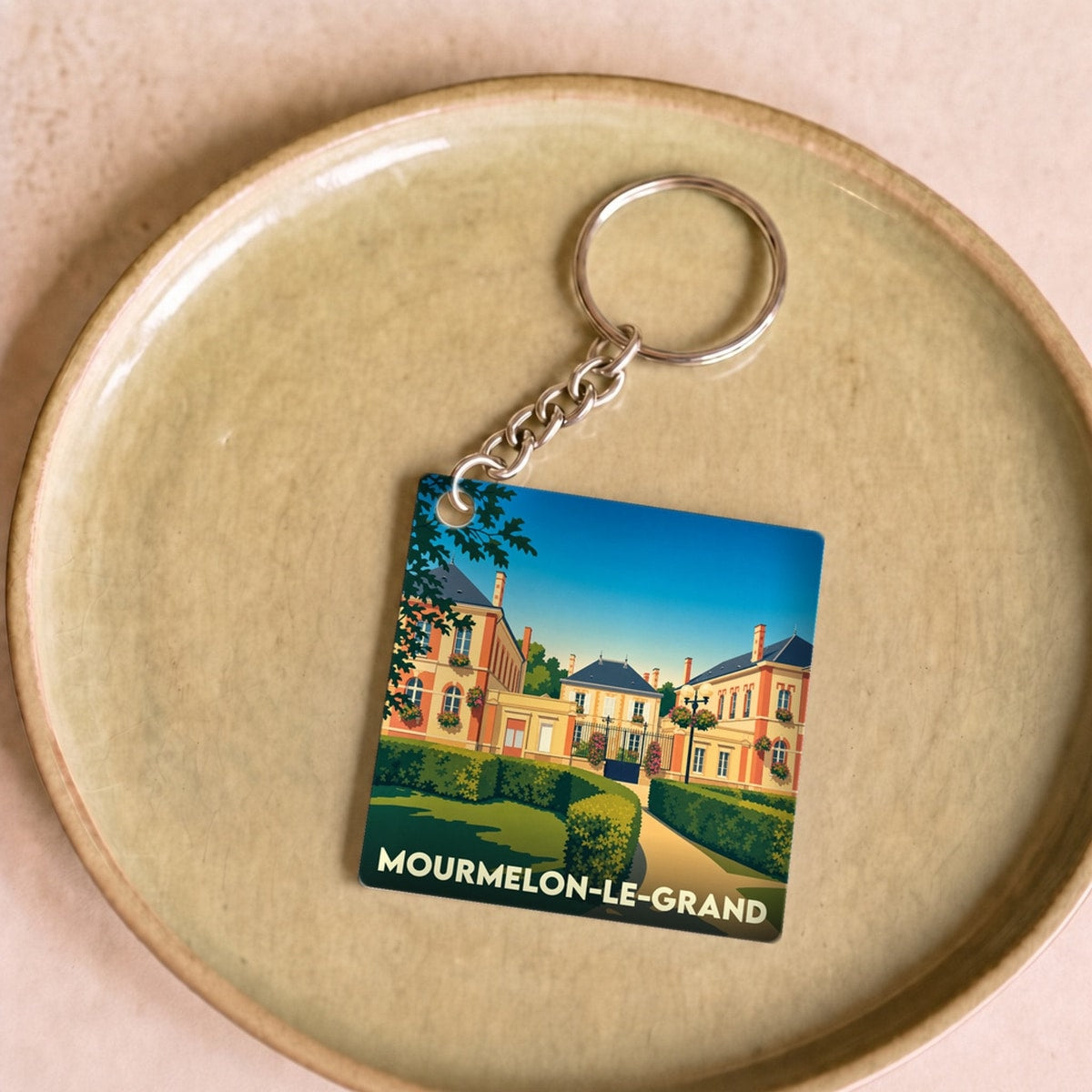 Porte-clés souvenir de la ville de Mourmelon-le-Grand avec une illustration stylisée.
