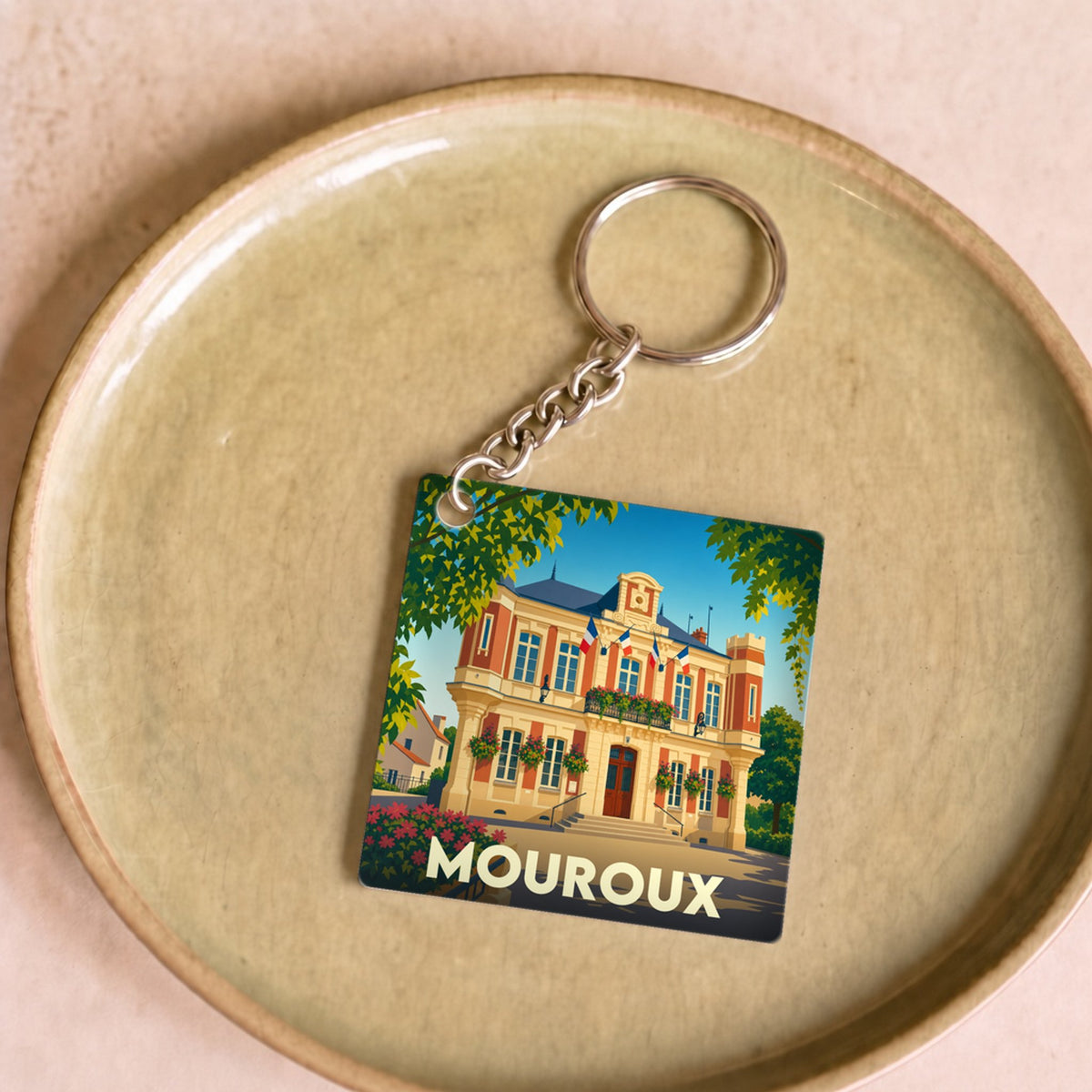 Porte-clés souvenir de la ville de Mouroux illustré d'une vue stylisée de la mairie.