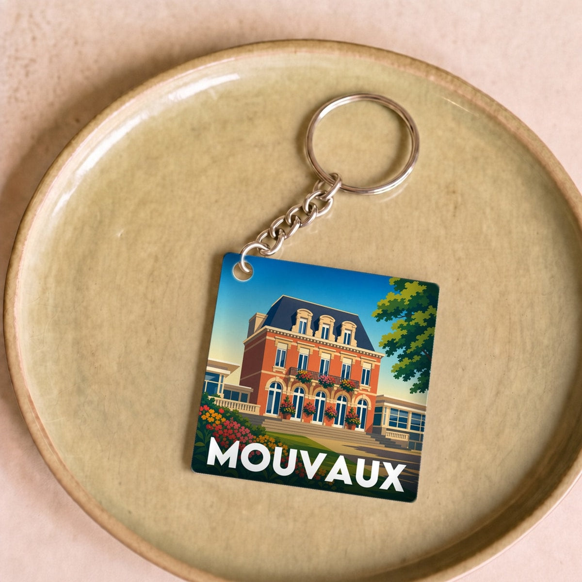 Porte-clés souvenir de la ville de Mouvaux avec une illustration stylisée.