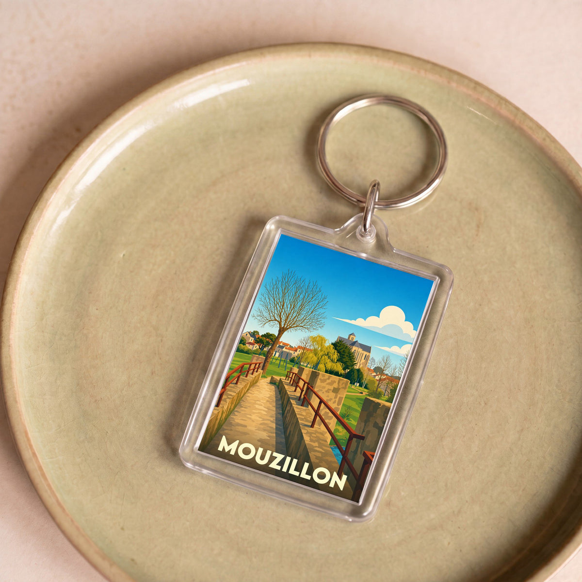 Porte-clés souvenir de la ville de Mouzillon avec une illustration stylisée d'un pont en pierre.